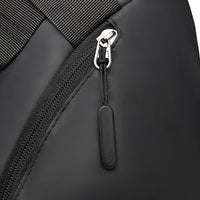 Close-up of a black backpack zipper with a silver pull tab on a white background