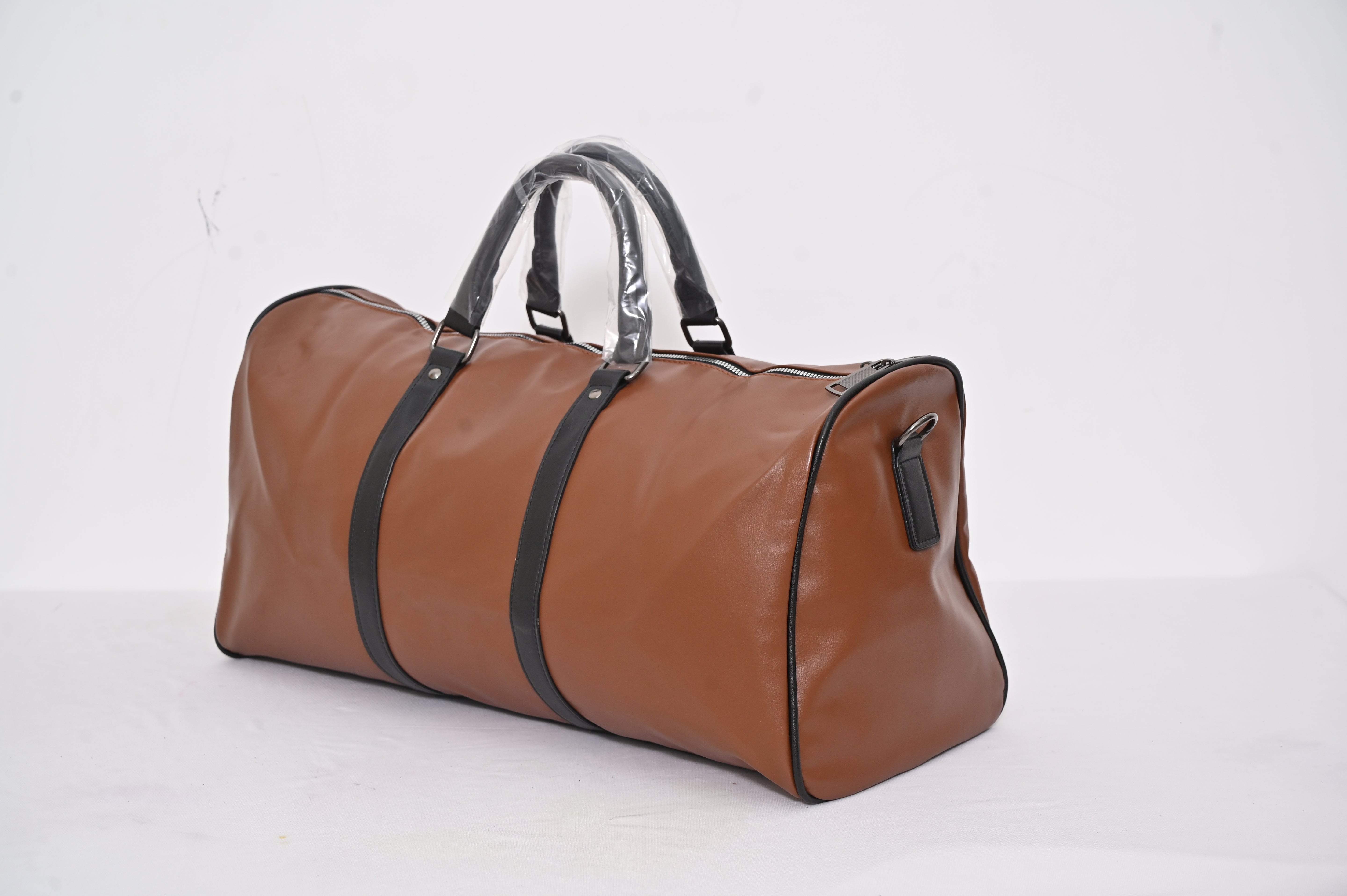 Brown duffel bag with black straps on a white background